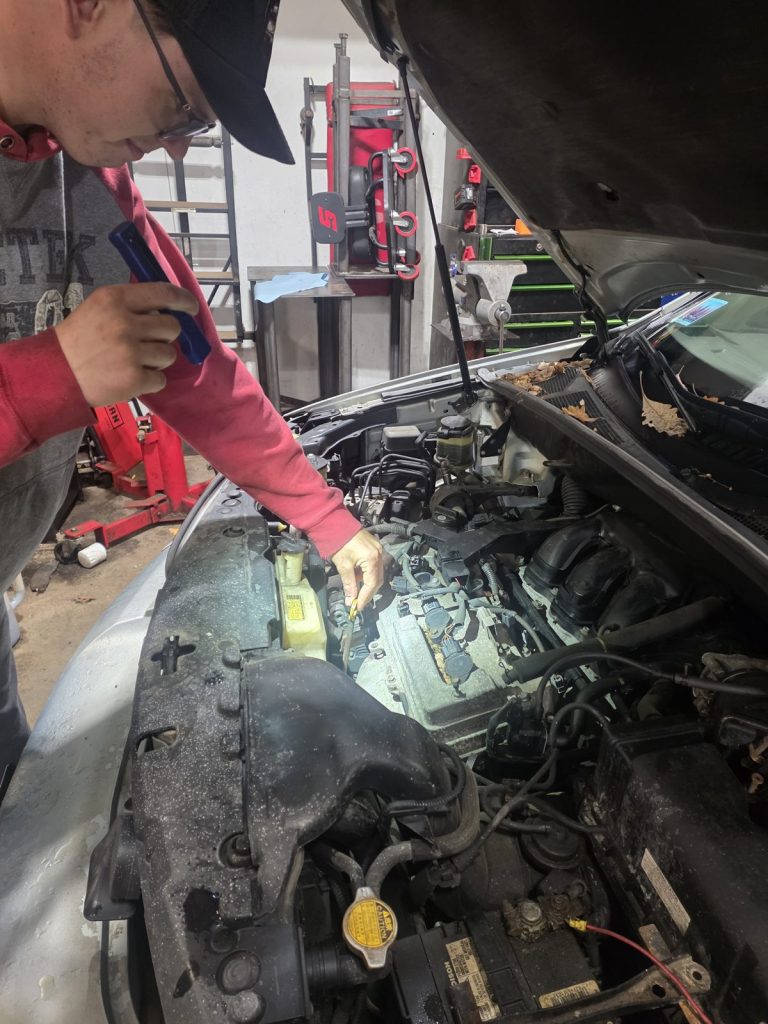 Under-hood inspection of an SUV at TinJToo Auto Repair in Star Prairie