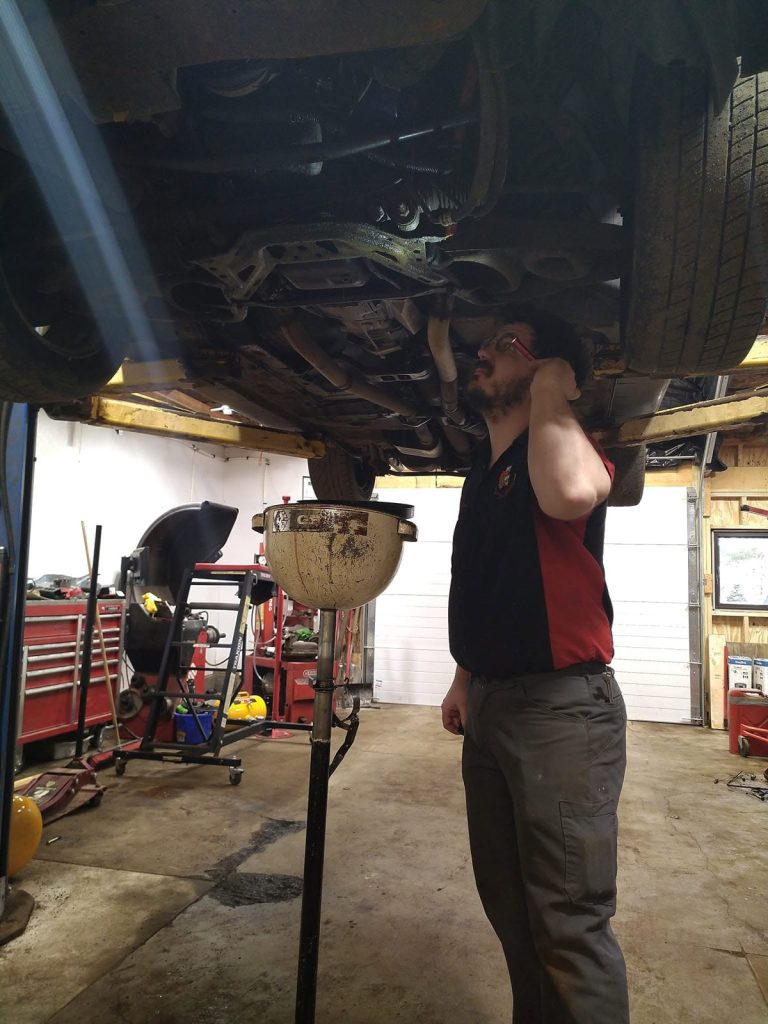 Transmission work under a lifted vehicle at TinJToo Auto Repair