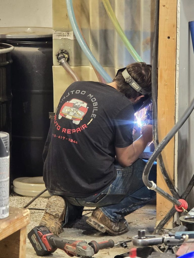 Technician welding in the TinJToo Auto Repair shop