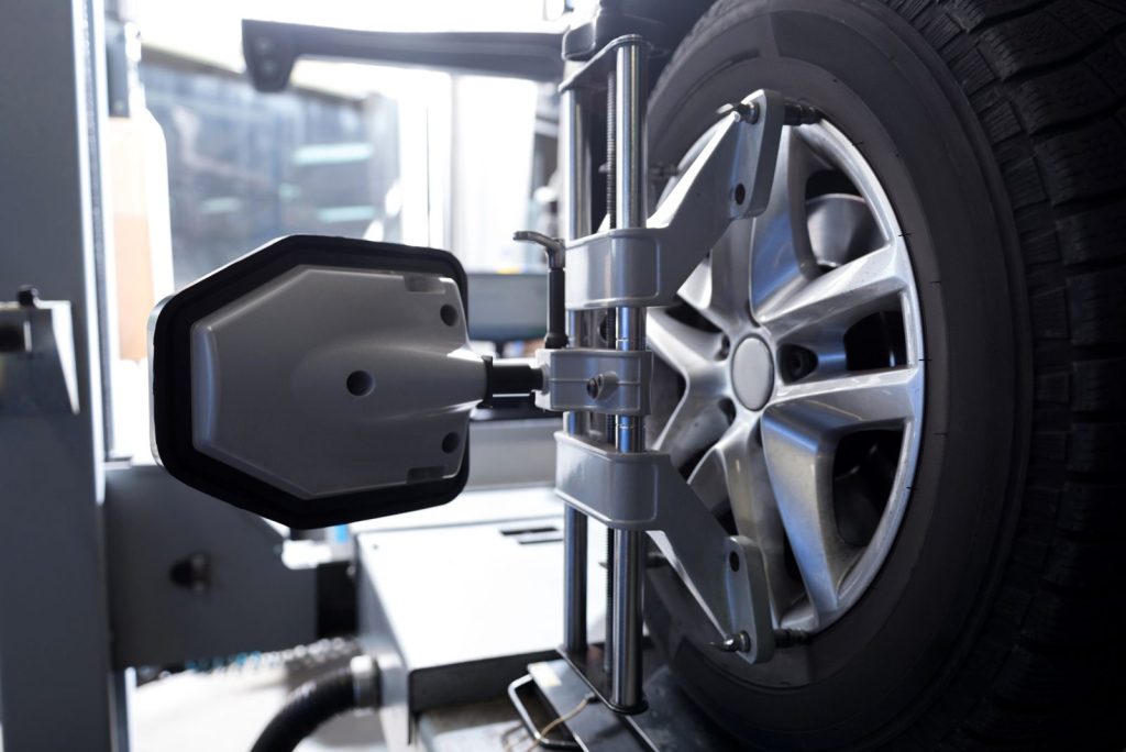 Wheel alignment sensor clamped to a car wheel during an alignment check